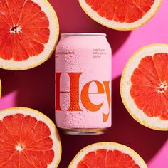 grapefruit and orange slices surrounding a can of jely soda on a pink background