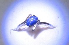 This solid 10K white gold ring is a bypass style, holding a 5x4mm cabochon of dark royal blue star sapphire (sapphires like this are almost always lab created).  It looks like a blue opaque stone until it's under a bright pinpoint light source then it shows a 6 rayed white star.  The ring is size 5 3/4.  It's hallmarked 10K and weighs 1.5 grams.  Very good vintage condition! I don't do sizing, sorry.  Please note things look bigger on your device screen or monitor than they are in real life! That's why I quote measurements. Please also be aware that VINTAGE jewelry is not NEW jewelry; it has a 'history". I do want you to be happy, thus I do take returns with no restocking charge, but you are responsible for the tracked return of the item to me, and I will refund the purchase price when I r Blue Star Sapphire Ring, Star Sapphire Ring, Blue Star Sapphire, Star Sapphire, Blue Star, Solitaire Ring, White Gold Rings, Sapphire Ring, Sapphire