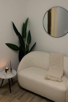 a white couch sitting next to a table with a mirror on it