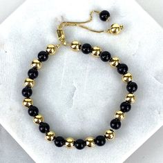 "18k Gold Filled 1mm Box Chain Bracelet Featuring Simulated Onyx Black Bead Ball, Gold Beads, Adjustable Bracelet - Bracelet Size: Thickness: 0.9 mm | Beads Width: 5.8 mm | Length: 9 Inches 💎 With new products daily, quality and competitive prices, in DiJu Jewelry you find the most unique styles of modern designs, always looking for elegance and market trends. *Helping your Jewelry Businesses Grow *Starting your Own Business *Making your Own Collection: DiJu Jewelry ever brings Better Moments f Luxury Classic Black Gold Bracelet, Adjustable Gold Beaded Bracelets With Gemstone, Elegant Black Beaded Bracelet With Adjustable Chain, Adjustable Black Bracelets With Gold Beads, Adjustable Chain Jewelry With Round Beads, Adjustable Gold Onyx Bracelets, Adjustable Gold Onyx Bracelet, Gold Beaded Bracelets With Onyx Gemstones, Adjustable Onyx Bead Jewelry