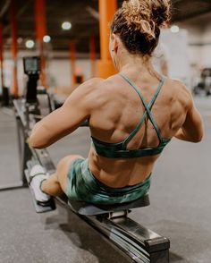 a woman sitting on top of a bench in a gym