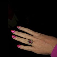 a woman's hand with pink manicures and a ring on her finger