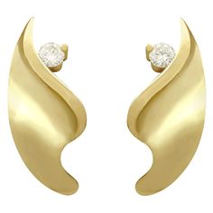 An impressive pair of vintage 0.18 carat diamond and 18 karat yellow gold stud earrings; part of our diverse diamond jewelry and estate jewelry collections. These fine and impressive vintage diamond earrings have been crafted in 18k yellow gold. Each earring has an undulating, curvilinear organic design, ornamented with a single claw set transitional modern brilliant round cut diamond. These earrings for pierced ears secure to the reverse with a post and butterfly style fastening. Each of the bu 1950s Earrings, Vintage Diamond Earrings, Yellow Gold Stud Earrings, Butterfly Style, Transitional Modern, Yellow Gold Earrings, Leaf Jewelry, Organic Design, Gold Stud Earrings