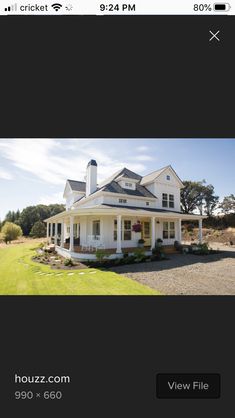 a large white house sitting on top of a lush green field