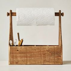 a wooden box with a roll of toilet paper on the top and two toothbrushes in it