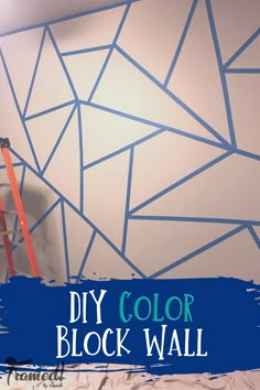 a man is painting a wall with blue paint on it and the words diy color block wall above him