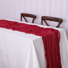 the table is set with two chairs and a red blanket draped over it's edge