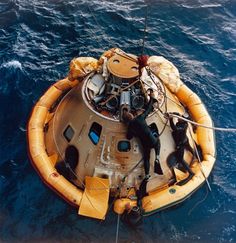 two men on a raft in the middle of the ocean with ropes attached to it