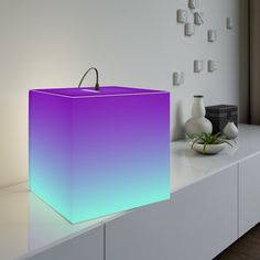 a purple and blue box sitting on top of a white counter next to a vase