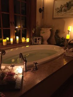 a bathtub with candles lit in the background