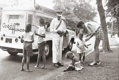 black and white photograph of people standing in front of an ice cream truck with their children