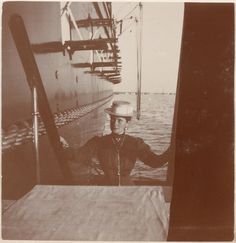 an old black and white photo of a man in a sailor's hat on the deck of a ship