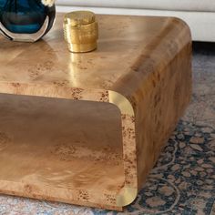 a coffee table with a vase on top of it and a rug underneath the table