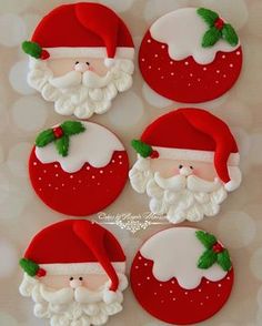 four decorated cookies with santa clause on them