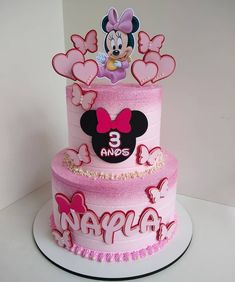 a three tiered birthday cake with minnie mouse on top