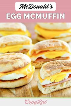 eggs, ham and cheese on english muffins are arranged on a cutting board