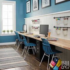 an office with blue walls and wooden desks in front of two pictures on the wall