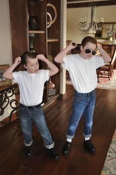 two young boys standing in front of a mirror