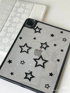 an iphone case with black and white stars on the back, next to a laptop