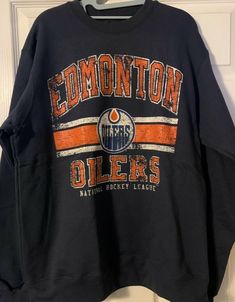 an edmonton oilers sweatshirt hanging on a door