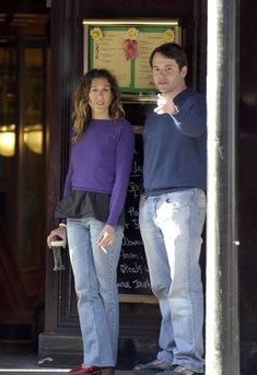 a man and woman standing in front of a building