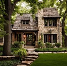 a stone house surrounded by trees and grass