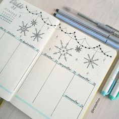 an open planner with snowflakes on it next to a pen and two markers