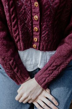 a close up of a person wearing a sweater and jeans