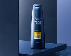 a bottle of dove men's care shampoo on a countertop in front of a blue wall