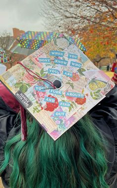 a person with green hair wearing a graduation cap