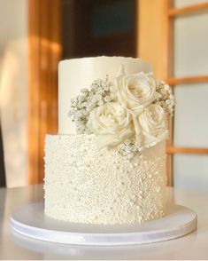 a white wedding cake with flowers on top