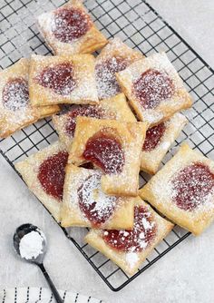 powdered sugar and jelly pastries on a cooling rack