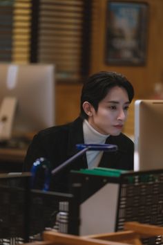 a man sitting in front of a computer monitor