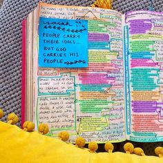 an open book with writing on it and yellow pom poms around the edges