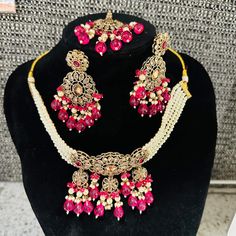 Beautiful brass based Polki Kundan and Moti Jwellery set . Comes with maang tikka , earrings and a choker necklace. The set is finished beautifully at the back with meenakari...the set comes in pastel shades of pink and green and is just splendid. Its intricate designs and stunning details add an elegant touch to your look. Upgrade your jewellery collection with this timeless set. Festive Gold Plated Tikka As A Gift, Bollywood Style Tikka With Intricate Design As Gift, Bollywood Style Tikka With Intricate Design, Gold Plated Chandbali Jewelry Sets For Celebration, Bollywood Style Intricate Design Gift Sets, Bollywood Style Gift Sets With Intricate Design, Brass Jewelry Sets With Intricate Design For Celebrations, Bollywood Style Gold Plated Jewelry For Celebration, Brass Jewelry Sets For Festive Celebrations