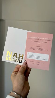 a person holding up a pink and white brochure with the words nah brand on it