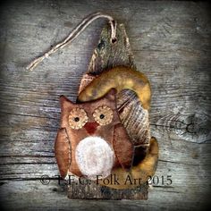 an owl ornament hanging on a wooden wall