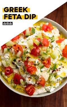 greek feta dip with tomatoes, cucumbers and herbs in a white bowl