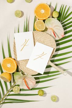 two cards with the letter k on them surrounded by citrus slices and palm fronds