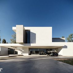 two cars are parked in front of a white building that is designed to look like a house