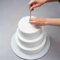 a woman is placing several plates on top of a cake