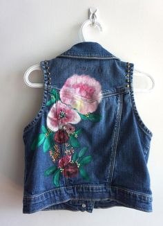 Inspired by the beautiful peony flower. This is a thrifted Gap Kids denim vest in a size L. I hand painted the floral crown on the back and added brass studs along the arms. I added three patches on the front, butterflies and a flower. All patches are reinforced with hand stitching. This vest can be machine washed on gentle or hand washed. All vests and jackets are one of a kind. Personalization is free. Casual Fitted Vest With Floral Embroidery, Fitted Denim Cotton Vest For Spring, Fitted Cotton Denim Vest For Spring, Bohemian Floral Print Spring Vest, Bohemian Denim Vest For Spring, Casual Denim Vest With Floral Embroidery For Spring, Casual Floral Embroidered Denim Vest For Spring, Summer Cotton Denim Vest With Floral Embroidery, Sleeveless Vintage Denim Jacket For Spring