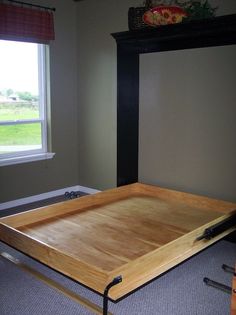 a wooden tray sitting on the floor in front of a window