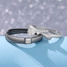 two wedding rings sitting on top of each other with one diamond in the middle and the other side