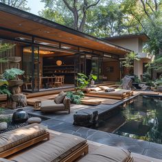 an outdoor living area with couches and tables next to a pool surrounded by trees