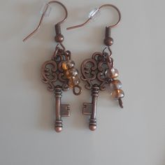 Beautiful Handcrafted Skeleton Key Earrings With 3 Sm Dangle Beads. Victorian/Reinassance Steampunk/Cosplay Skeleton Key Earrings, Steampunk Brown Jewelry For Gifts, Handmade Vintage Copper Beaded Earrings, Steampunk Brown Jewelry Gift, Steampunk Brown Jewelry For Gift, Brown Steampunk Jewelry Gift, Handmade Bronze Beaded Metal Earrings, Handmade Brown Steampunk Jewelry, Handmade Adjustable Steampunk Earrings