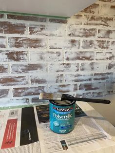 a paint can sitting on top of a table next to a baseball bat and newspaper