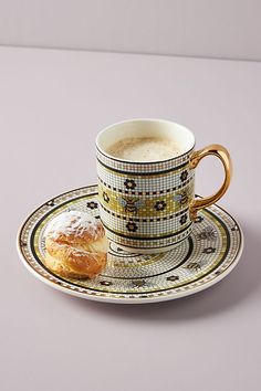 a cup and saucer with a pastry on it