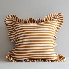 a brown and white striped pillow with ruffled edges