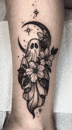 a woman's leg with flowers and a skull on the side, in black ink